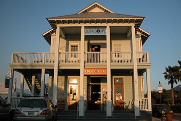 the Sundog Books building on Seaside, Florida’s Central Square glows in late afternoon sunlight against a clear blue sky