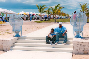 father and son sitting on terrace steps at the first Schooner Springfest in 2011, Schooner Bay, Bahamas