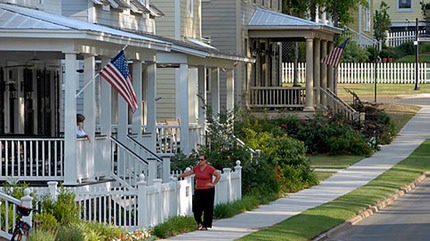 two women visiting, one standing on a porch and the other leaning against a picket fence in the Waters, near Montgomery, Alabama