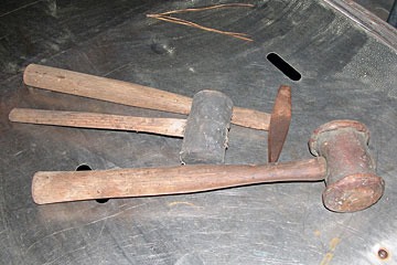 wood-handle hand tools lying on stainless steel surface