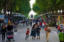 rambla with many people walking, flanked by post lamps and large trees, in Tarragonna, Spain
