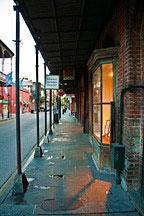 light spilling out of storefront bay window just after dawn in New Orleans