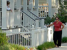 two women visiting at the Waters near Montgomery, Alabama; one leaning on her porch rail and the other leaning against the front picket fence